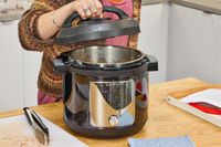A person lifts the lid of the Instant Pot Pro Plus Wi-Fi Smart 10-in-1 6-Quart Pressure Cooker