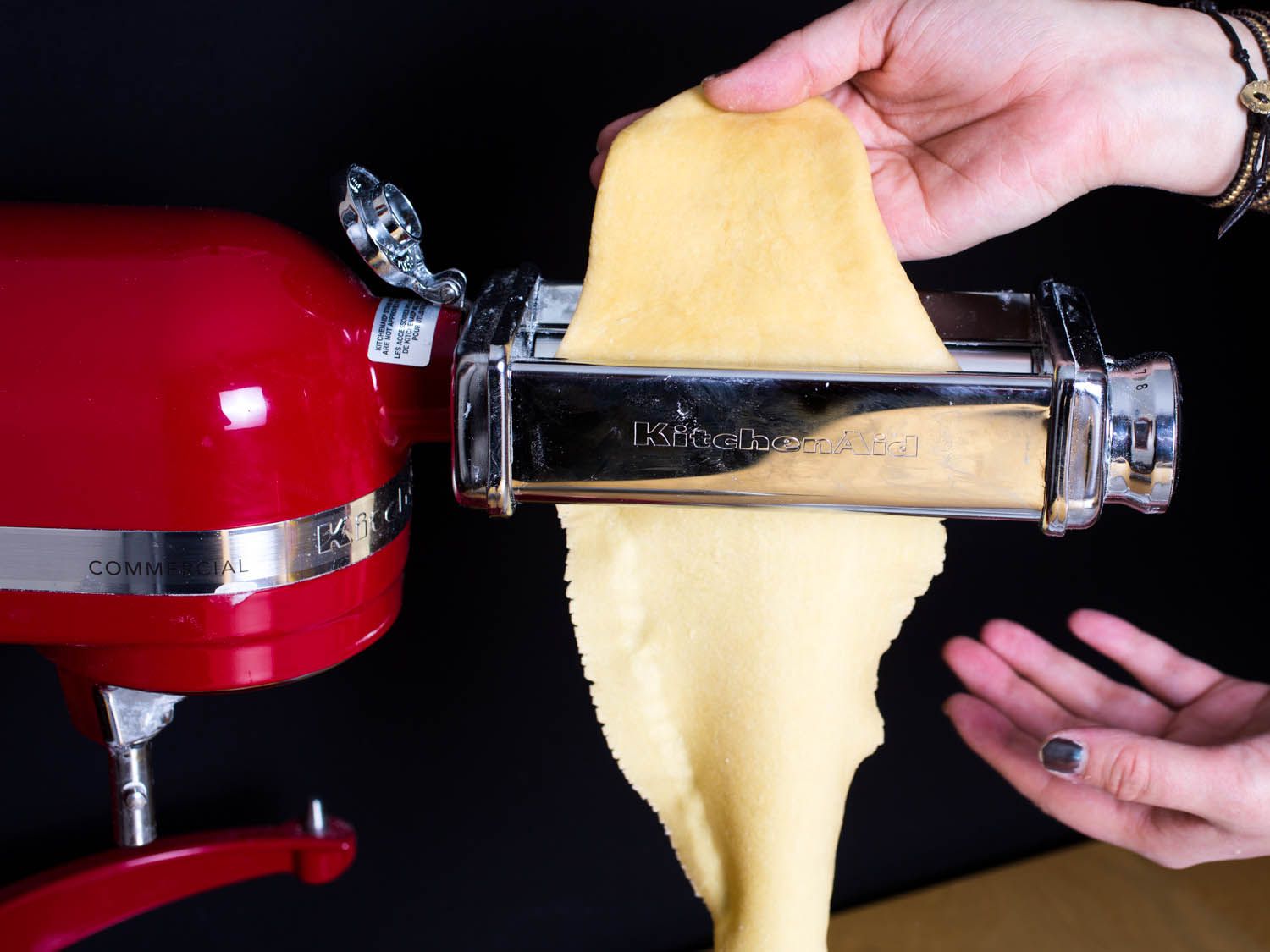 Demonstration of pasta dough fed through the wrong setting on a pasta roller and becoming jagged and bunched up.