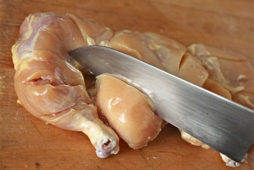 Making deep incision in Cornish hen.