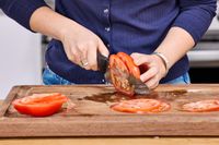 A person slices a tomato using the Mercer Culinary 8-Inch Millennia Chef's Knife
