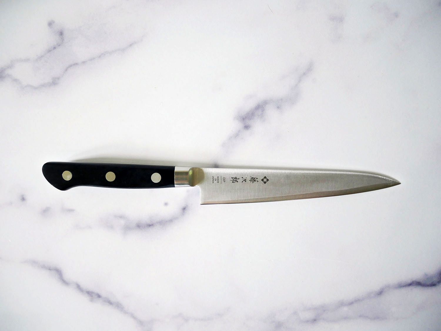 tojiro petty knife on marble countertop