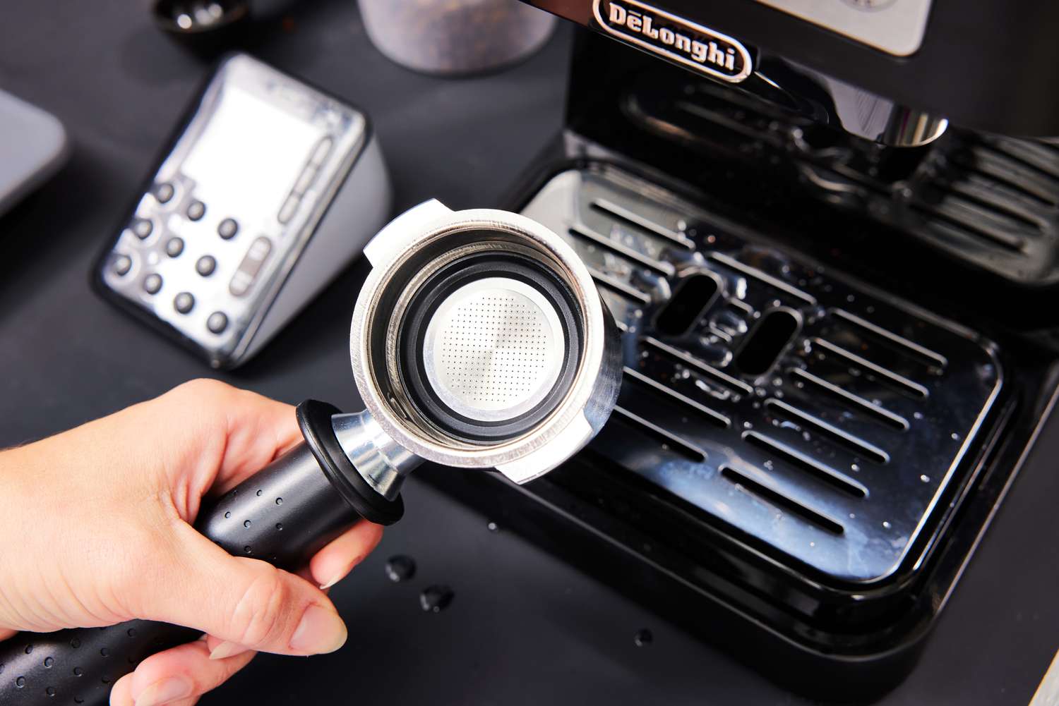 Closeup of a hand holding the portafilter that will go into the De'Longhi Stilosa Espresso Machine