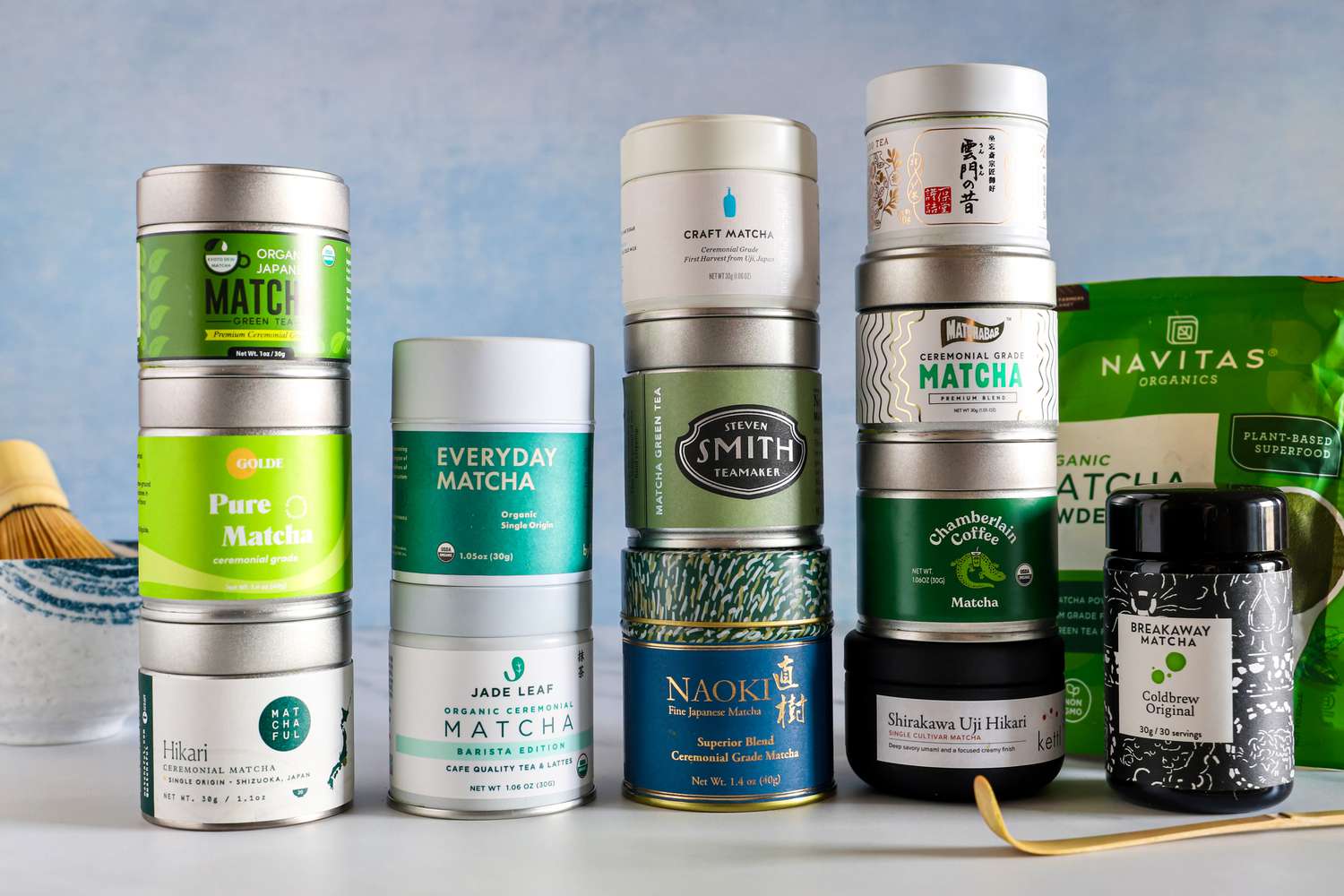 Numerous tins of matcha stacked on top of each other.