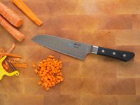 mac hollow edge santoku on a cutting board with cubed carrots