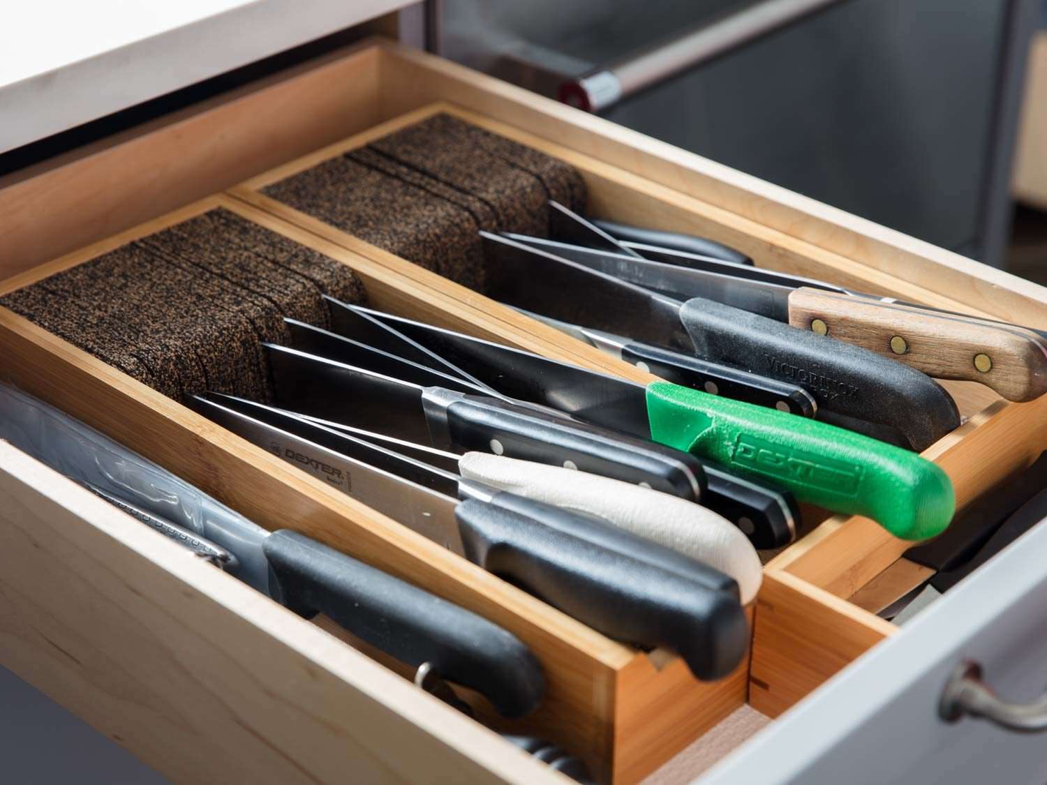 A kitchen drawer knife holder, shown in the drawer with knives in it.