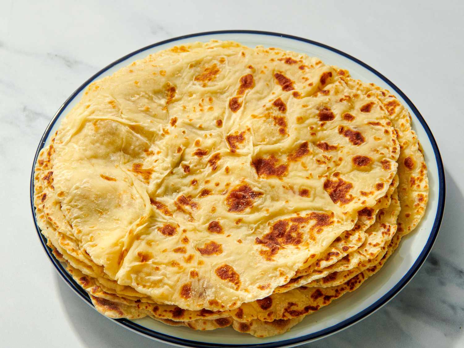 A plate of lefse a traditional Scandinavian flatbread stacked neatly on a white plate