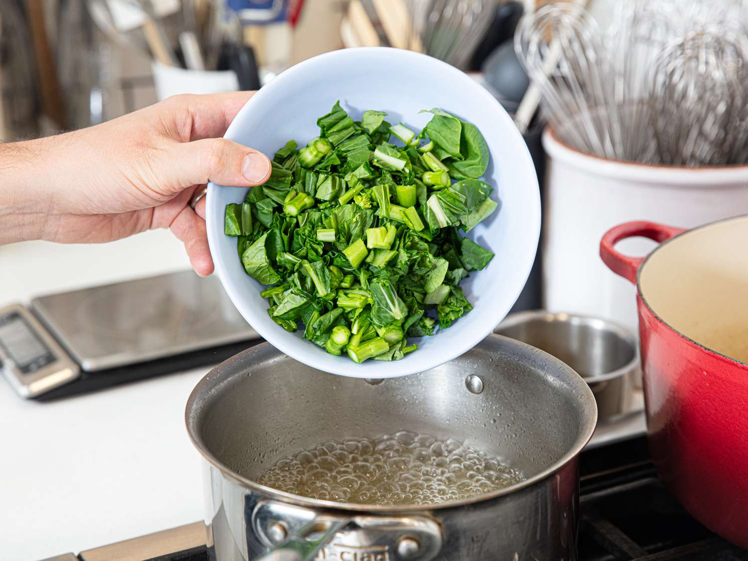 Side view of adding Chinese broccoli to boiling water