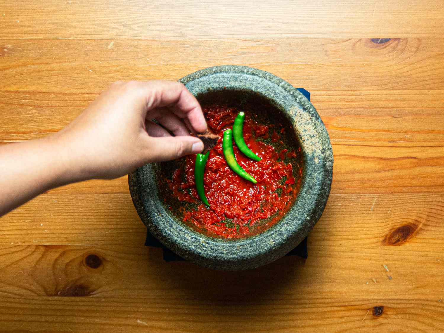 Overhead view of peppers add to mortar and pestle