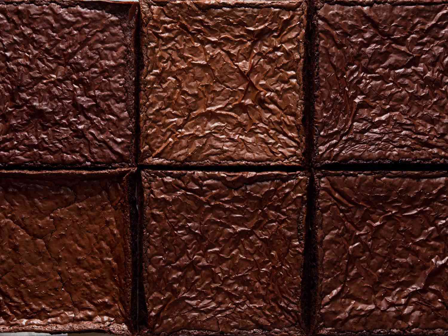 Overhead close-up of the crackly, dark-brown surface of brownies