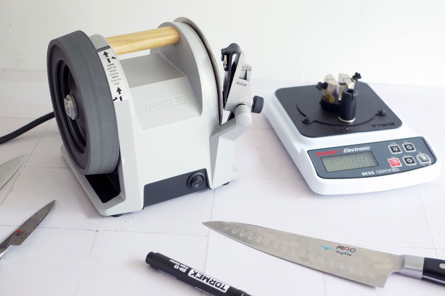 a knife sharpness reader next to the tormek knife sharpener and three knives