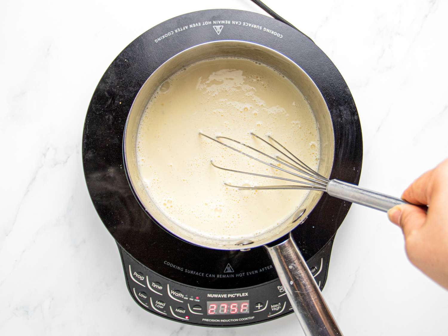 Whisk stirring mixture on an induction cooktop