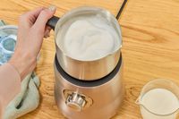 Frothed milk in a Breville milk frother.