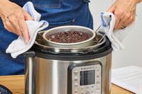 A person removes a cake baked in the Instant Pot Duo Plus 6-Quart 9-in-1 Pressure Cooker