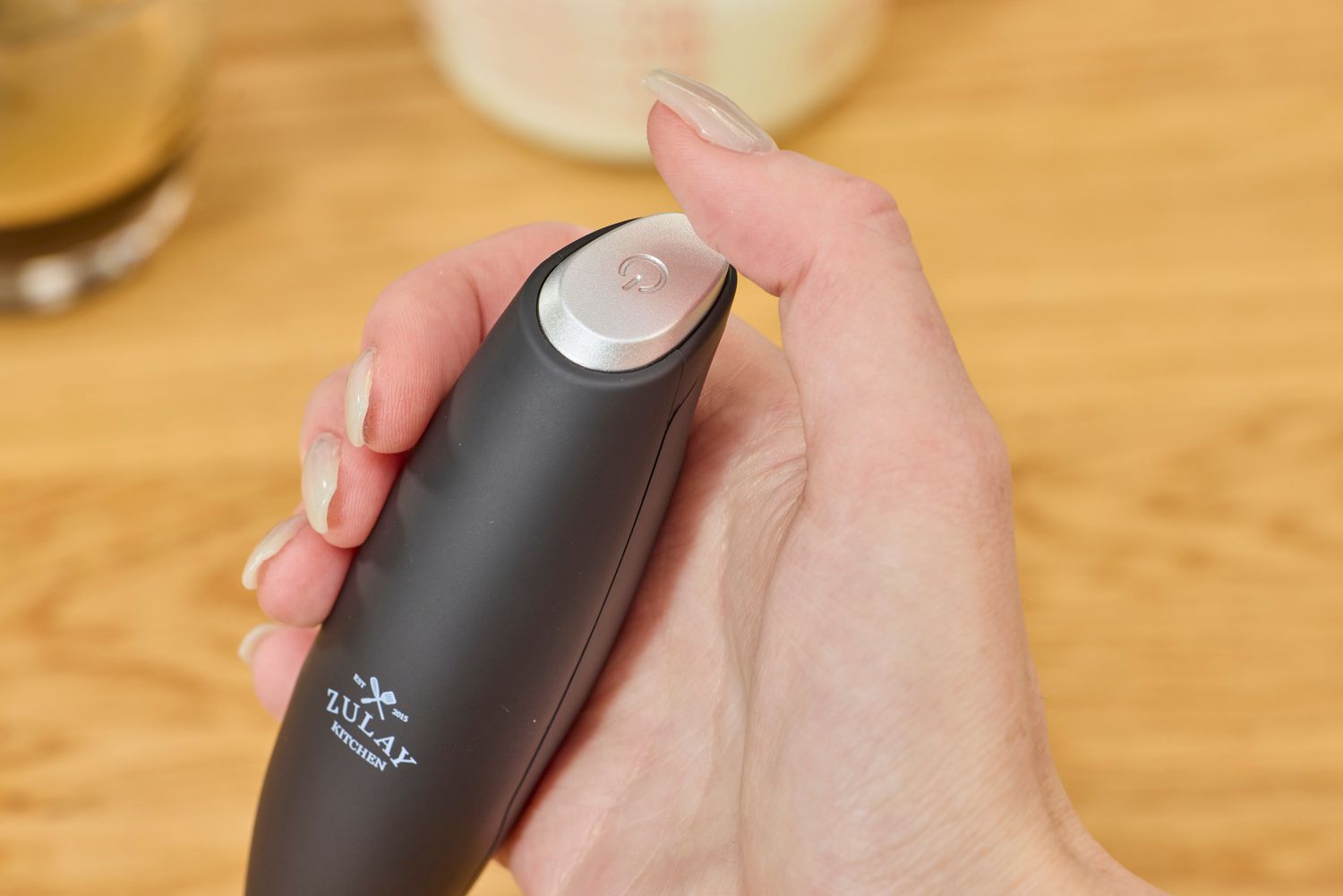 A person holding the Zulay milk frother.