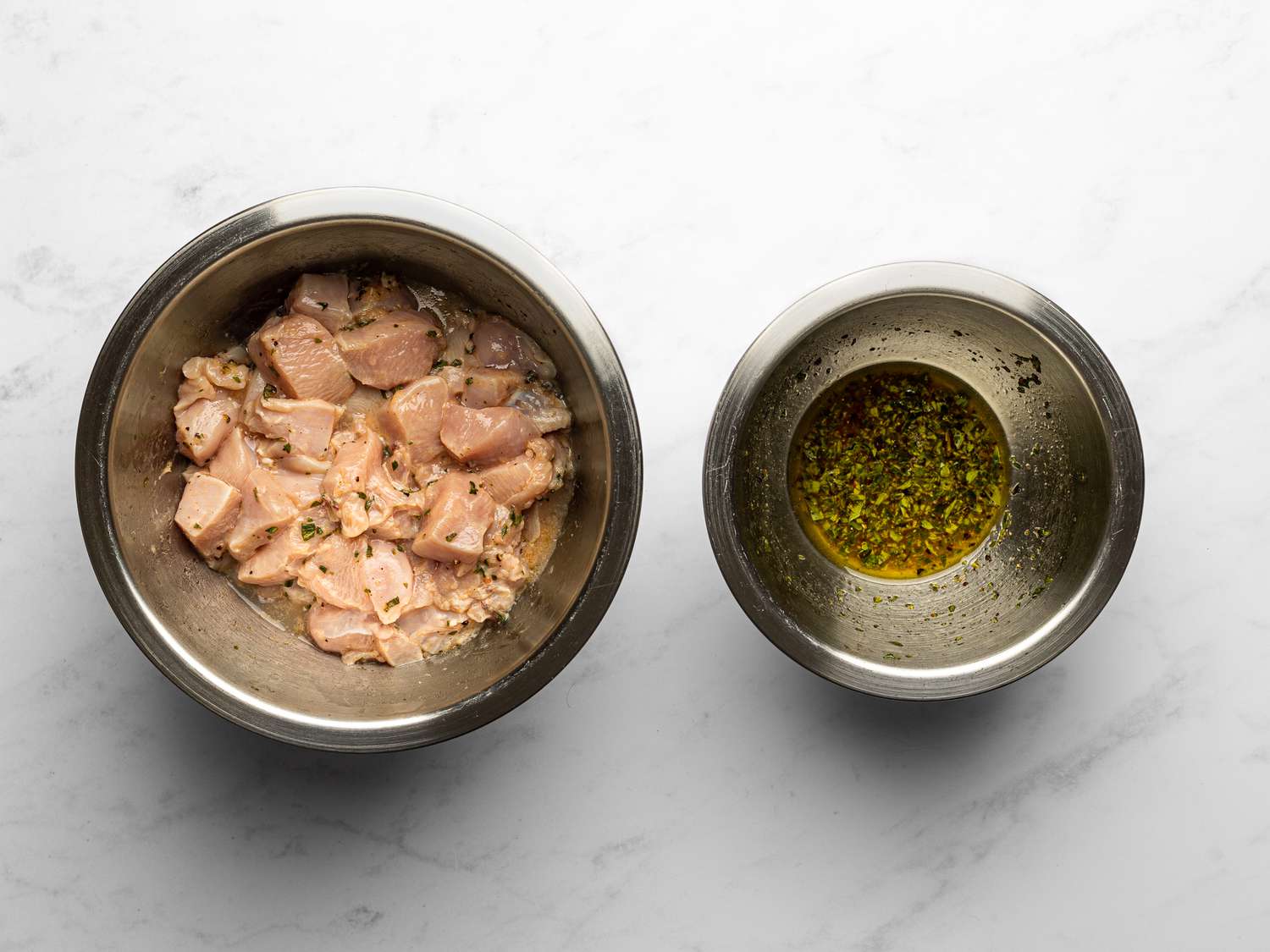 Lemon juice, vinegar, olive oil, oregano, salt, and black pepper whisked together in a medium bowl, and chicken evenly coated in grated garlic and dressing in a medium bowl