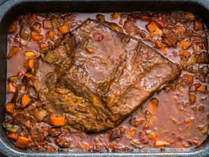 Overhead shot of a Jewish-style braised brisket in a sauce of carrots and onions