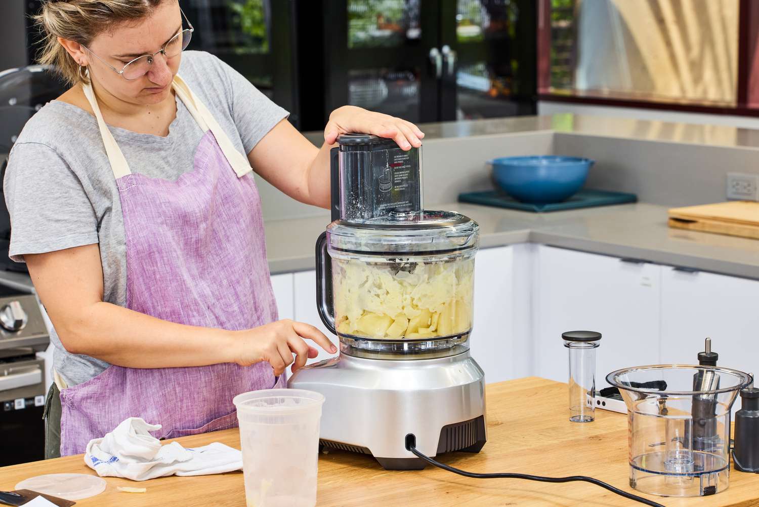 A person uses the Breville 16-Cup Sous Chef Peel & Dice Food Processor to chop food