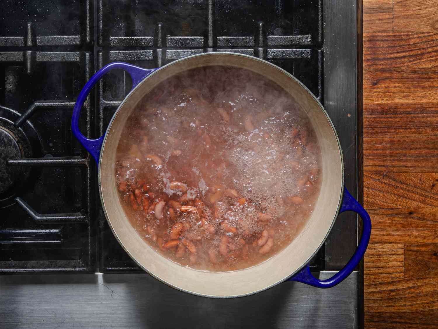 Overhead view of beans boiling in a pot