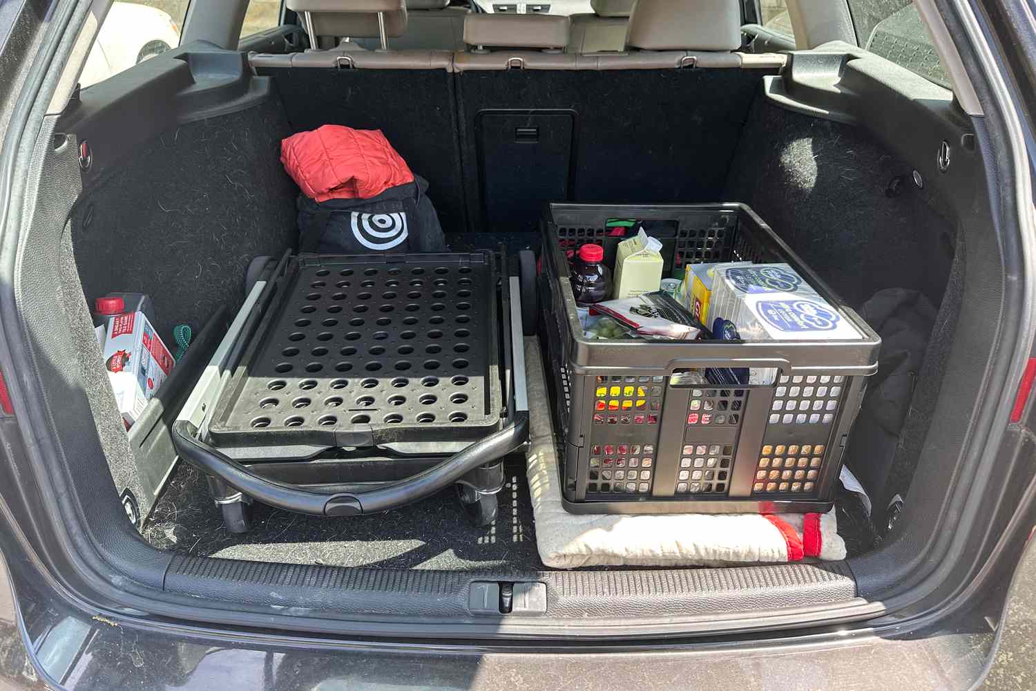 The folded up Clax cart in the trunk of a car.
