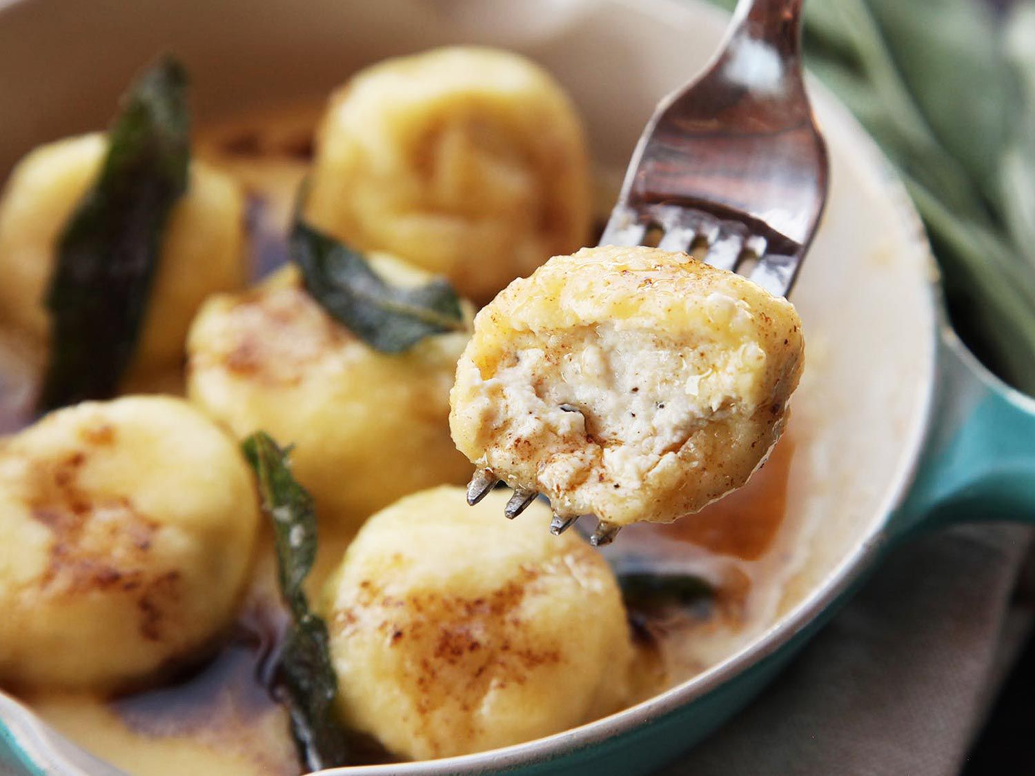 Half eaten ricotta ball resting on a fork. 