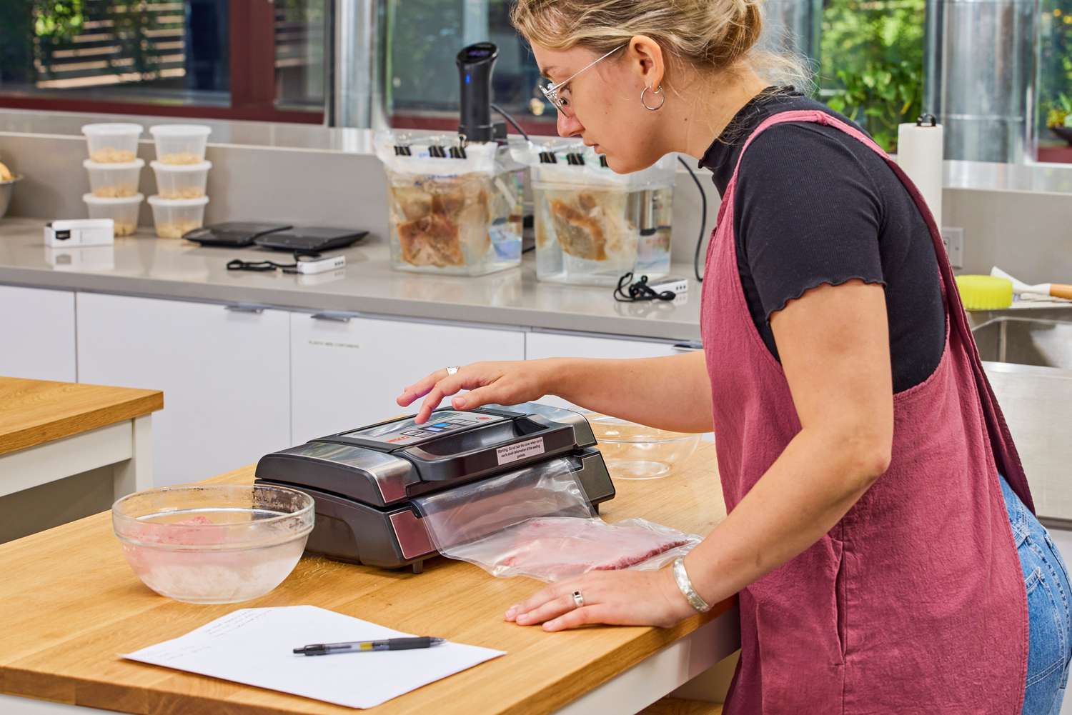 A person vacuum sealing a bag of meat using the Nesco VS-12 Deluxe Vacuum Sealer