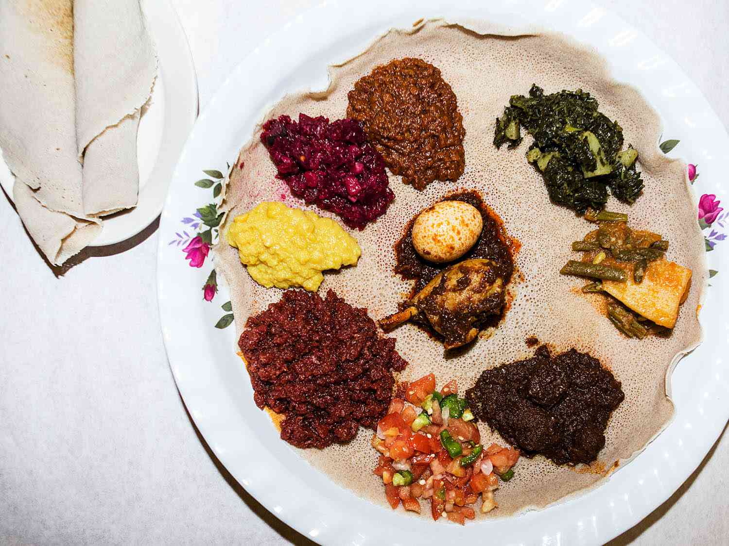 Ethiopian injera bread holding servings of vegetable dishes. 
