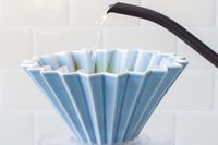 A kettle pouring water into the Origami dripper