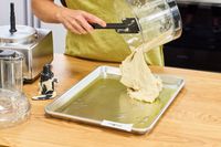 A person pours dough onto the Magimix 14-Cup Food Processor