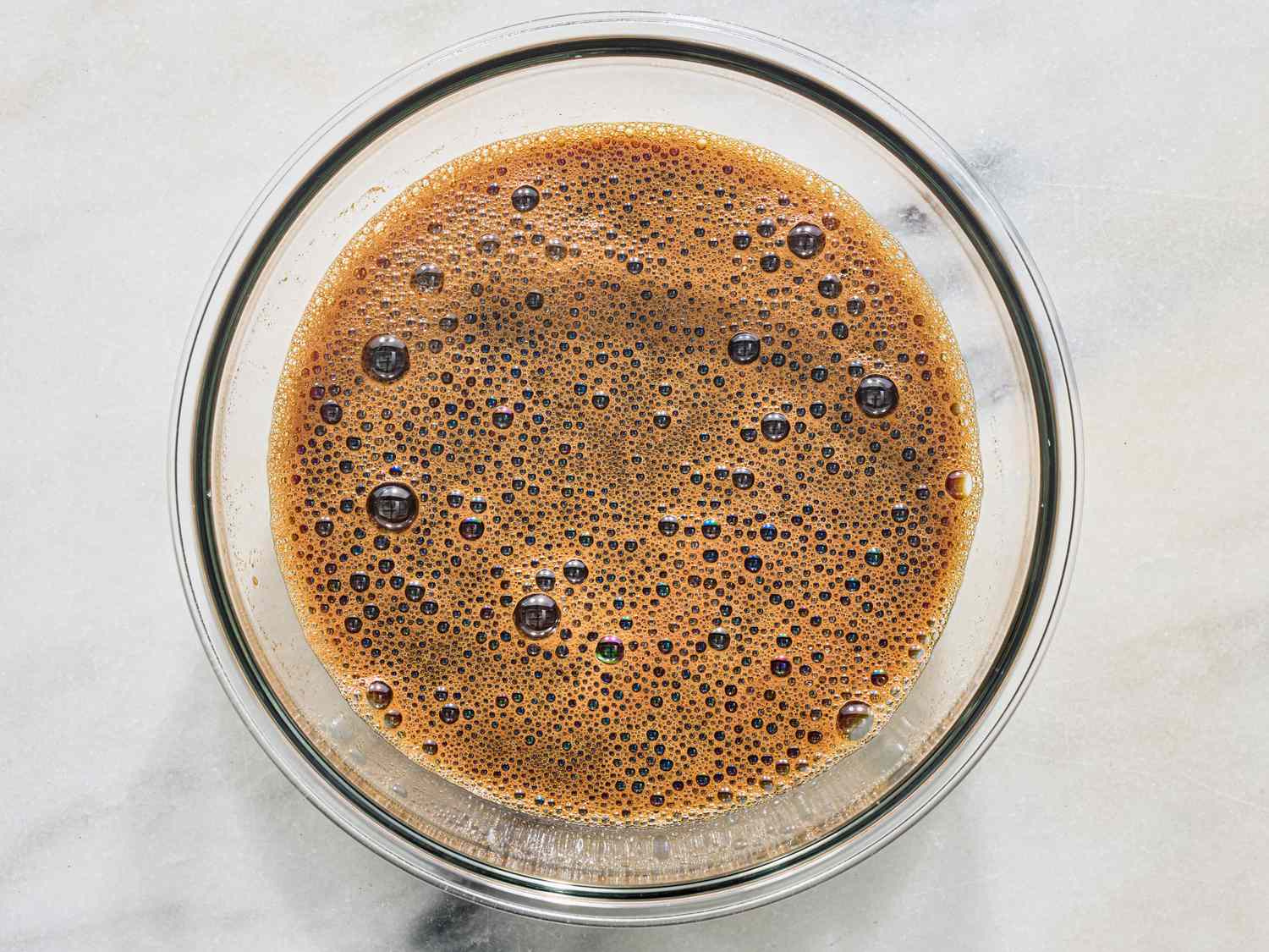 A glass bowl containing a frothy liquid