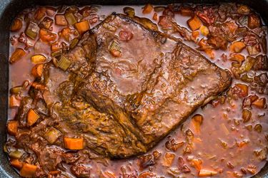 Overhead shot of a Jewish-style braised brisket in a sauce of carrots and onions