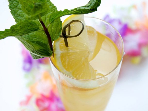 A Fog Cutter cocktail in a Collins glass garnished with a wedge of lemon and a sprig of mint.