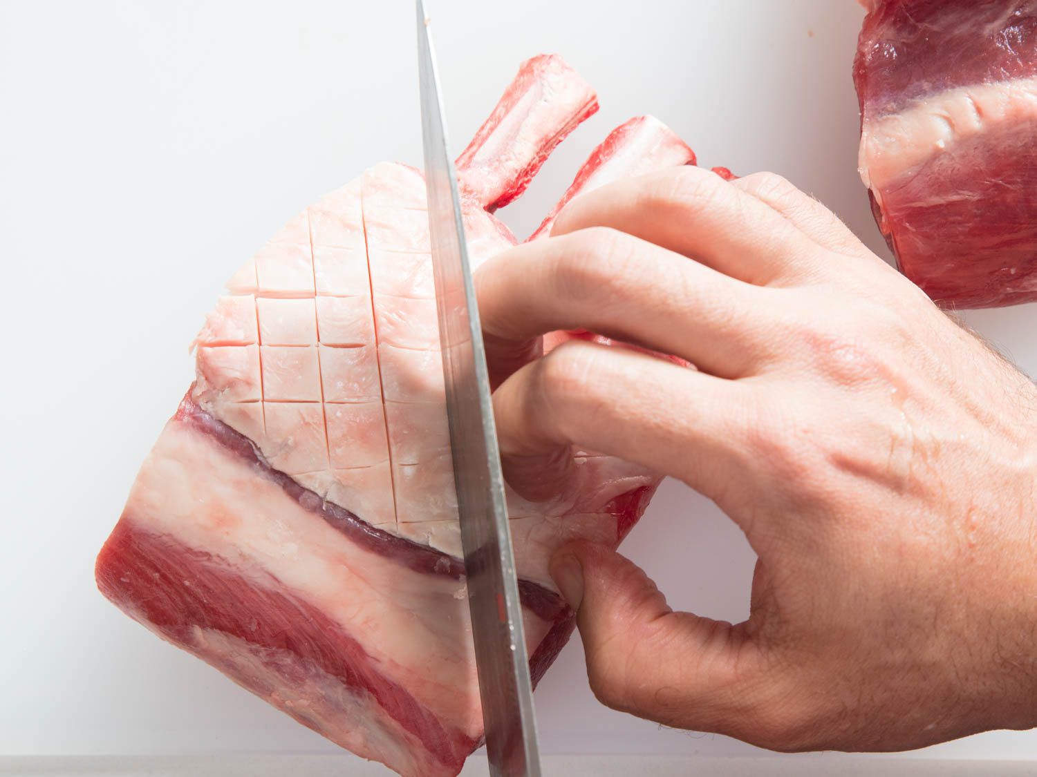 Scoring the fat cap on a rack of lamb