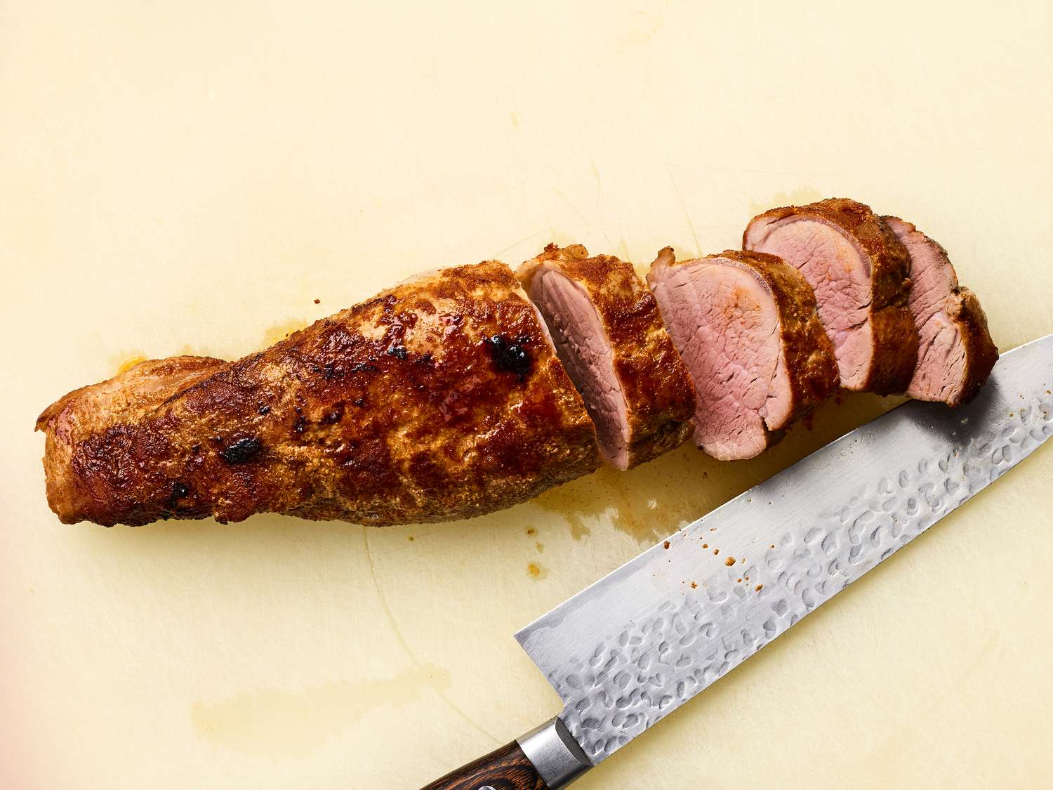 Sliced roasted pork tenderloin with a knife