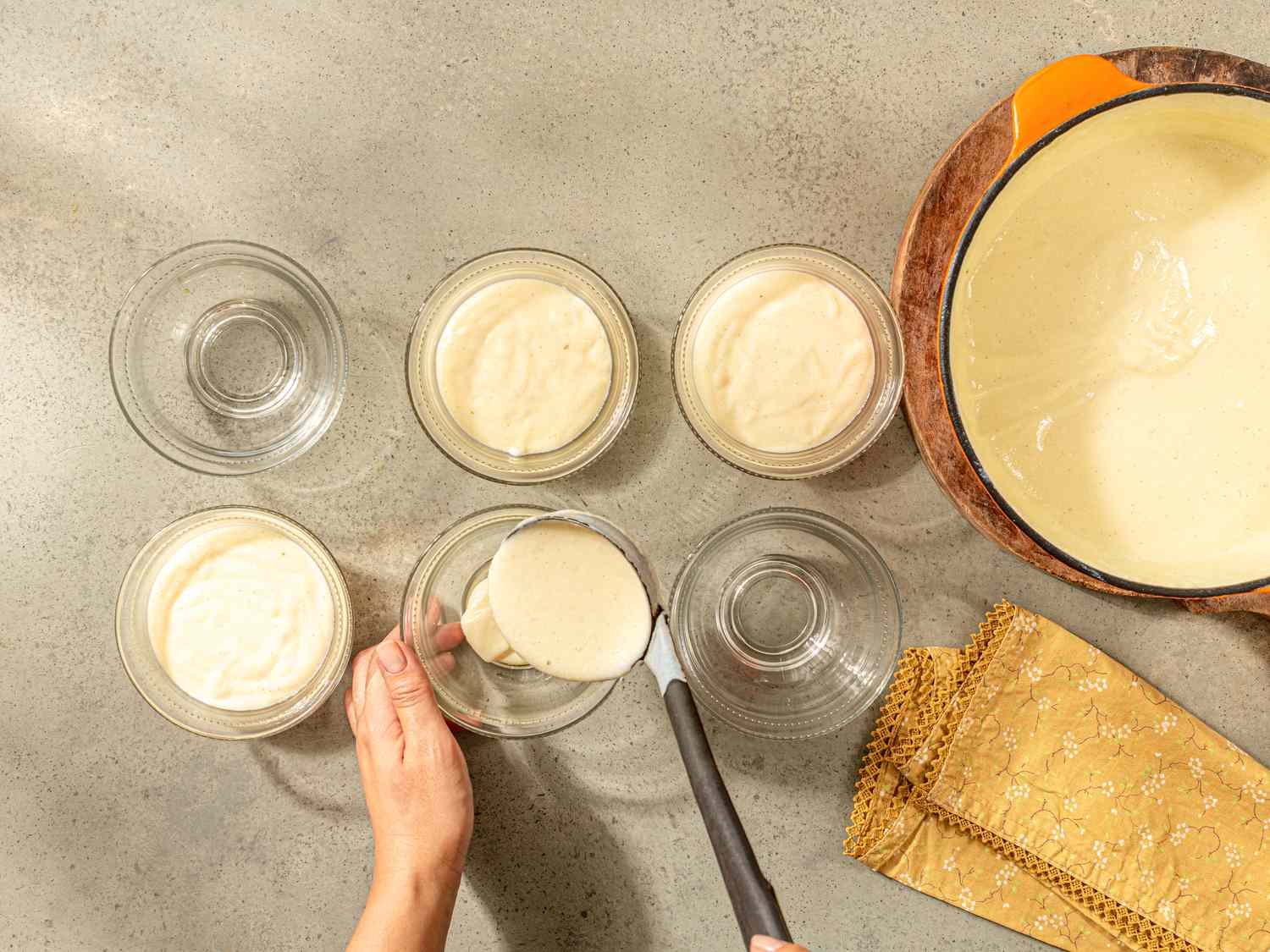 Overhead view of putting pudding into ramekins