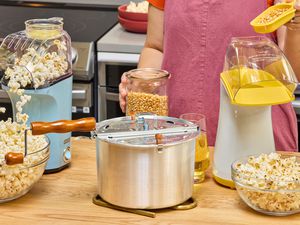 Three popcorn makers on a kitchen countertop.