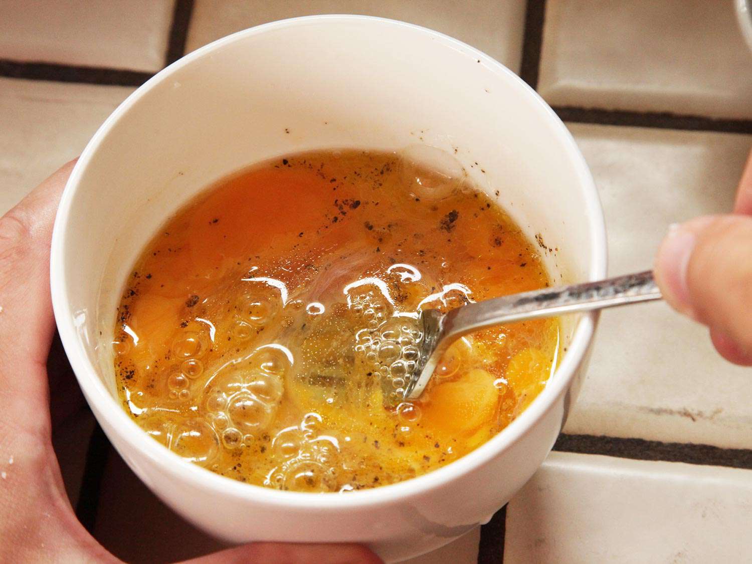 Gently beating seasoned eggs in a bowl for menemen
