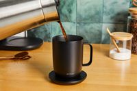 Coffee being poured from a carafe into an Ember smart mug.