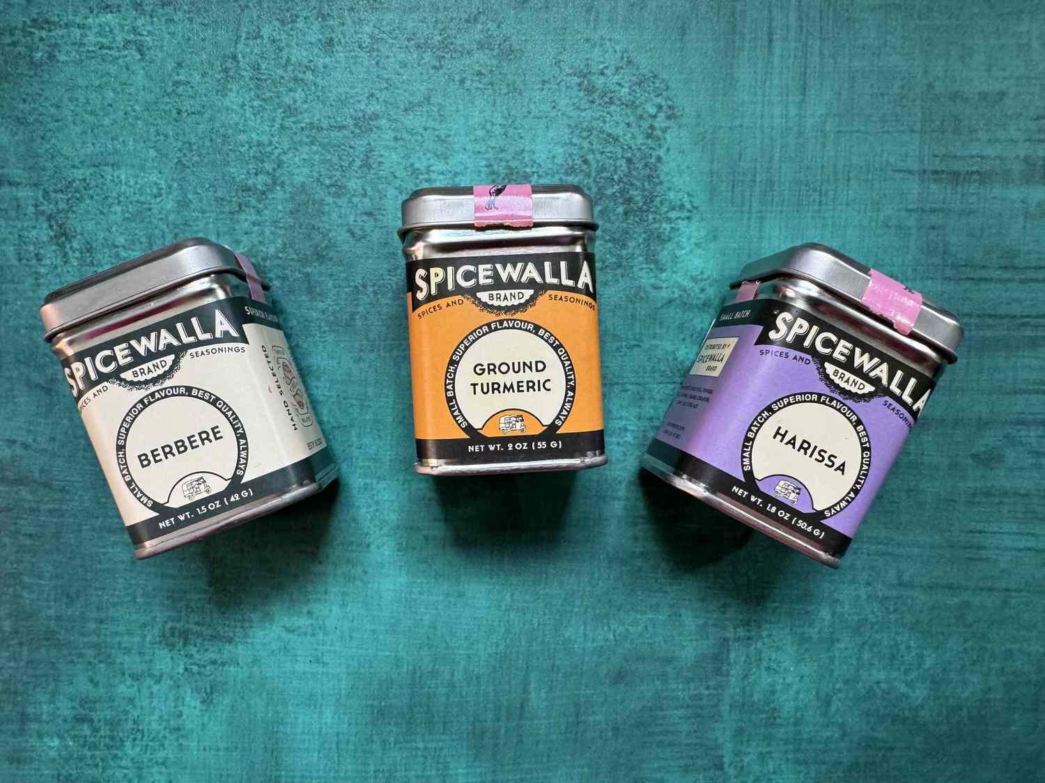 three tins of spicewalla spices on a blue green backdrop