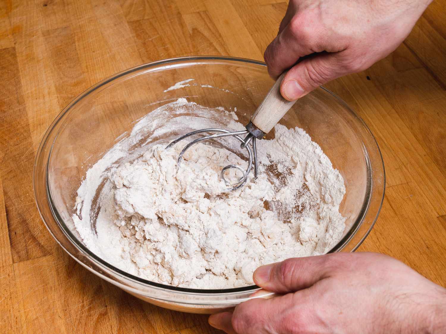 A Danish dough whisk incorporating flour and wet ingredients.