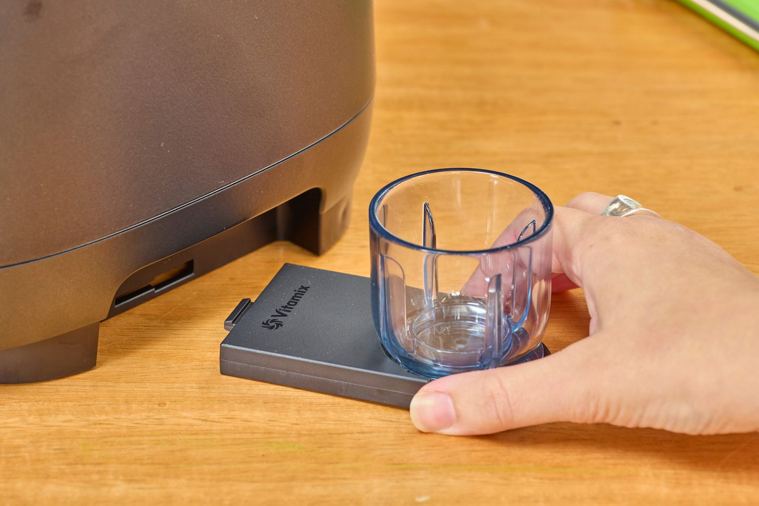 A hand holding a part to to the Vitamix Ascent X5 Blender