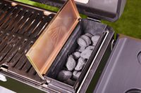 The charcoal storage compartment of the Masterbuilt portable charcoal grill.