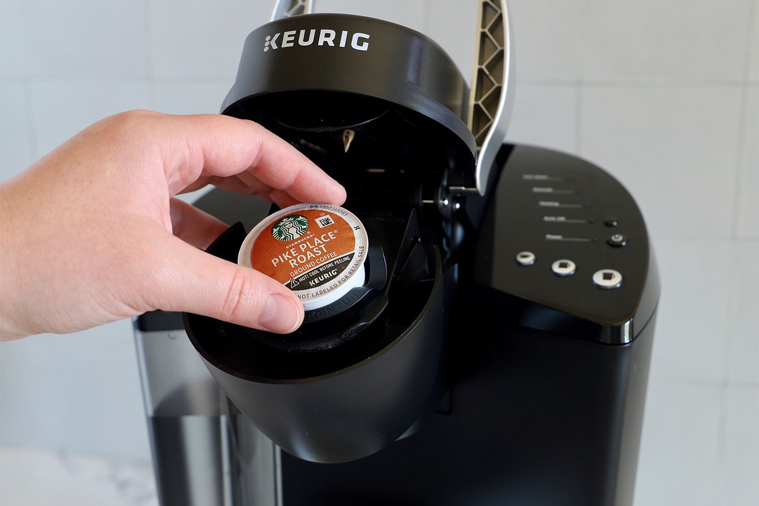 Person operating Keurig K-Classic Coffee Maker