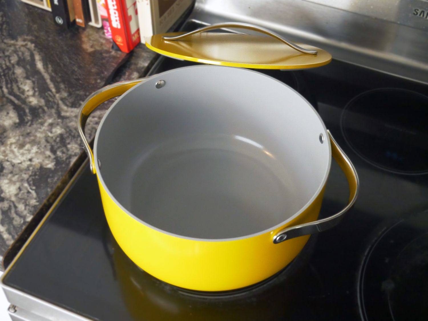 a yellow dutch oven with the lid to the side on a stovetop