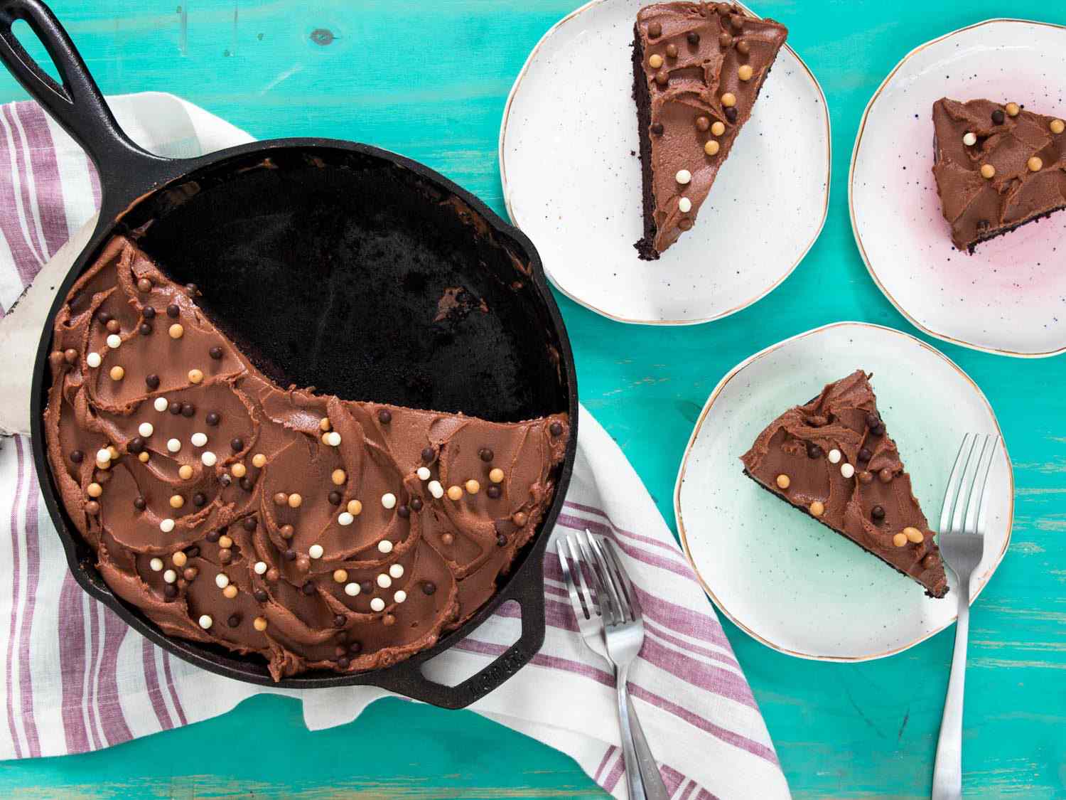 Overhead shot of chocolate skillet cake and plated slices of cake