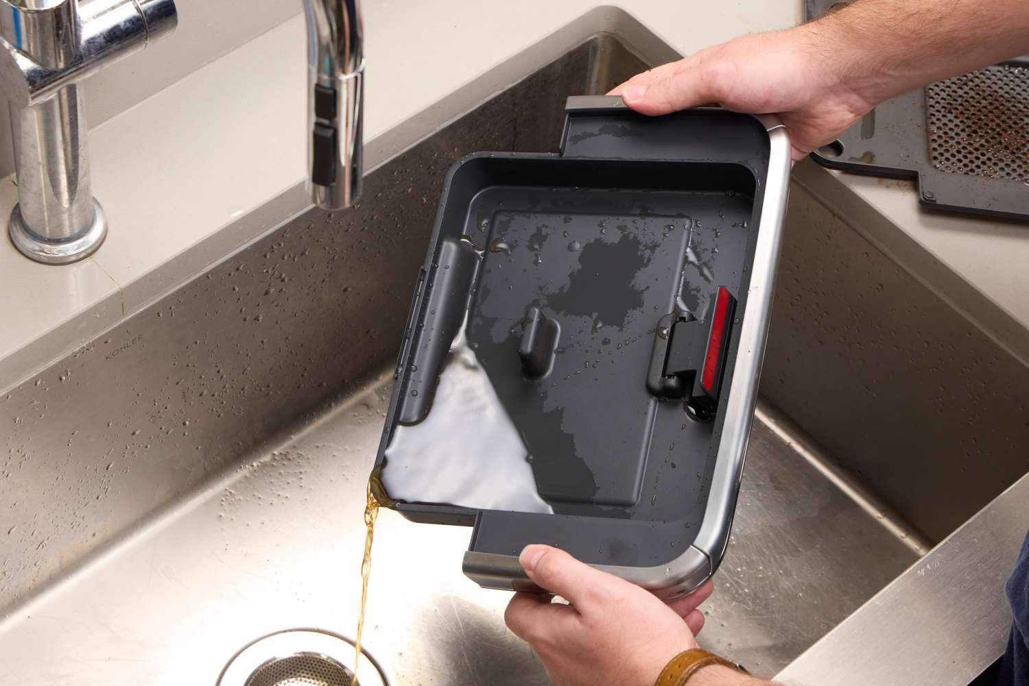 A person washes the parts of the Breville The Barista Pro Espresso Machine in a sink