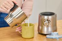Pouring milk from the Breville's pitcher into a mug.