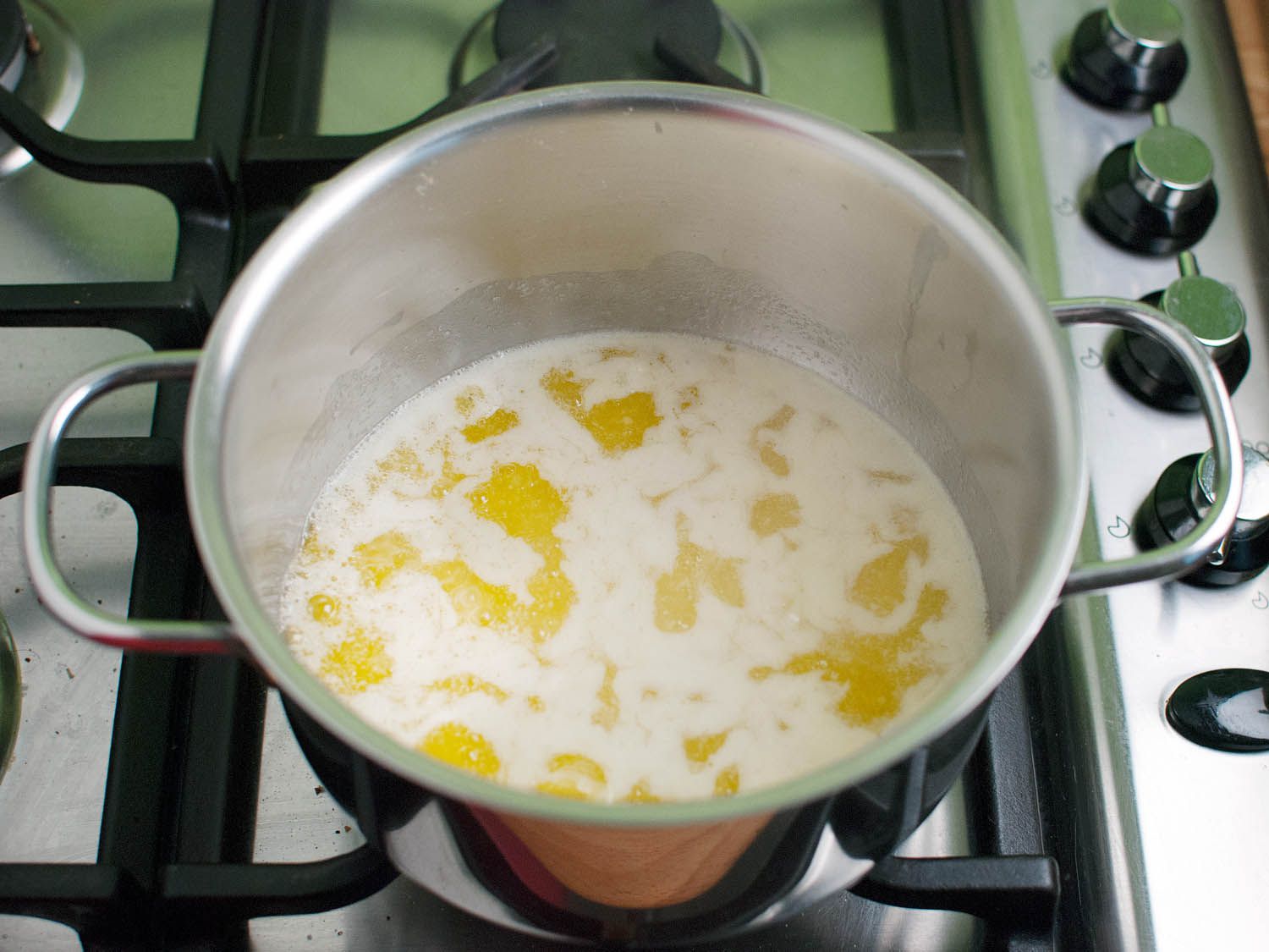 Melted butter in a metal pot on a stovetop.