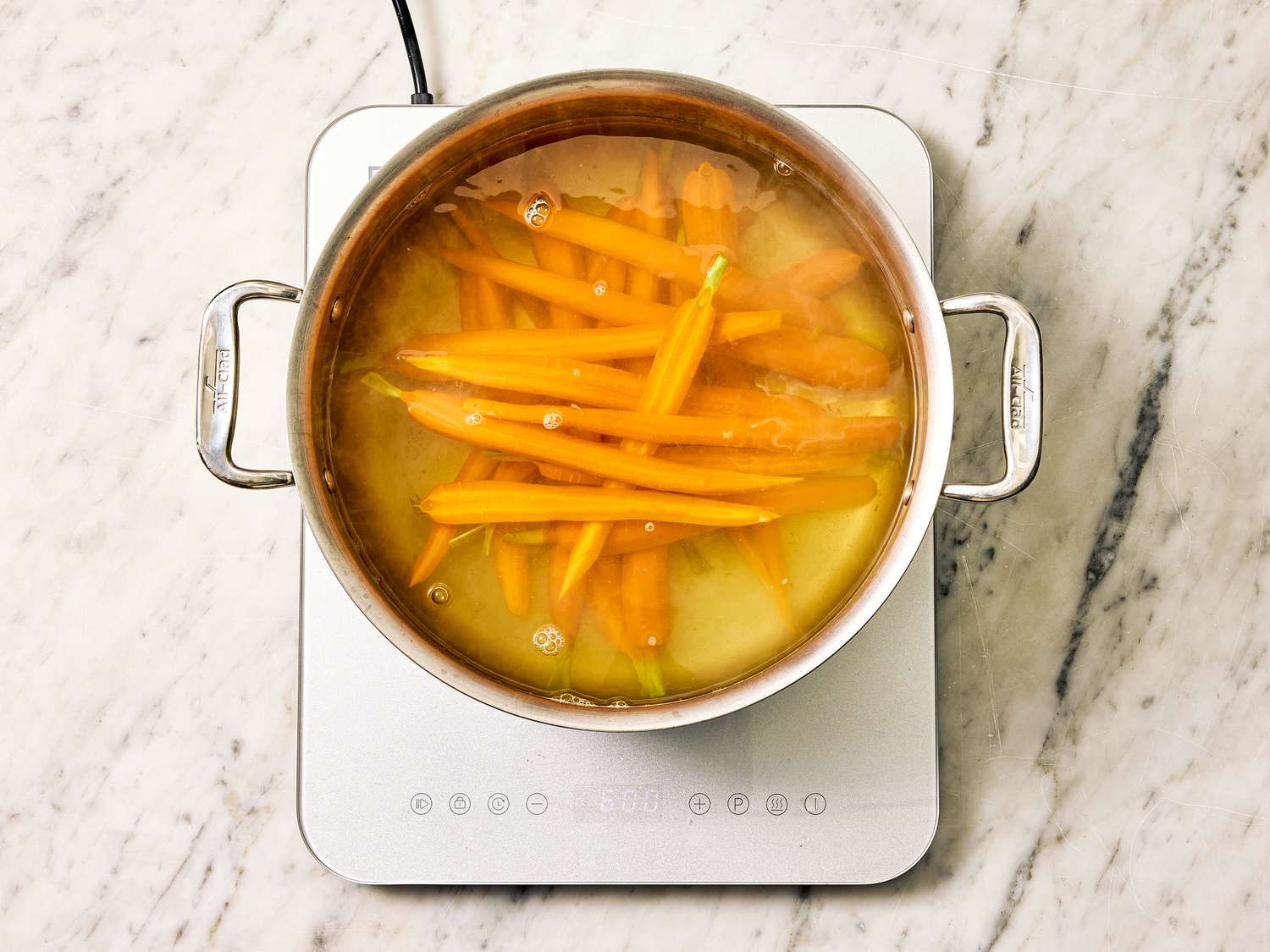 Carrots simmering in a pot of water on a stovetop