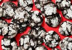 Chocolate crinkle cookies arranged on a red surface