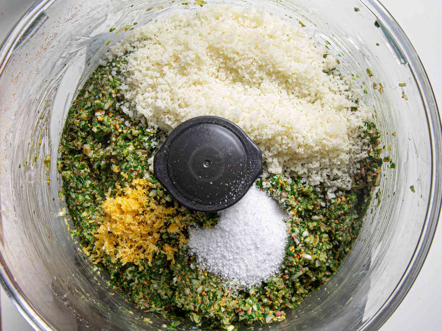 Overhead view of cheese added to pesto